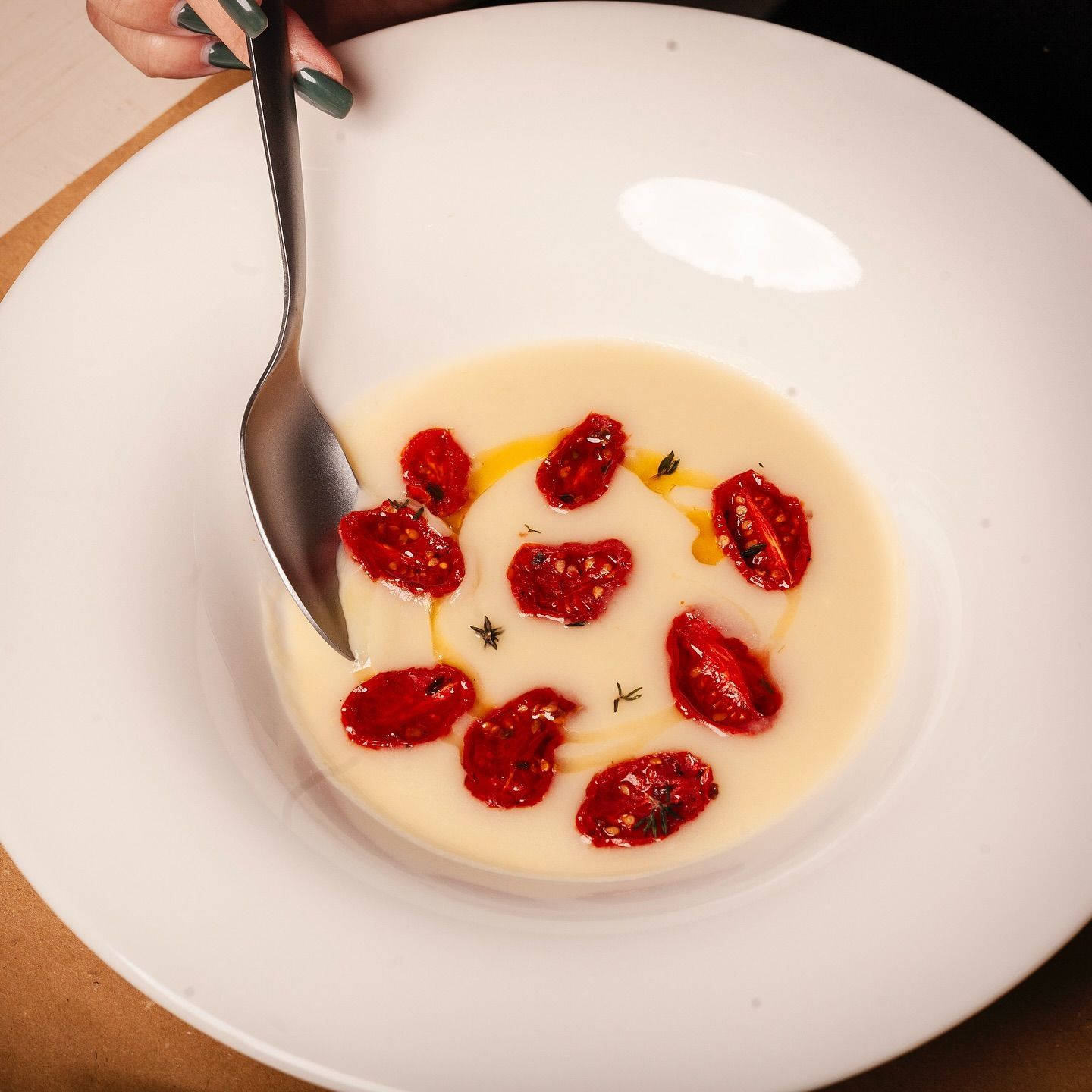 Una persona sta immergendo un cucchiaio in una ciotola di zuppa