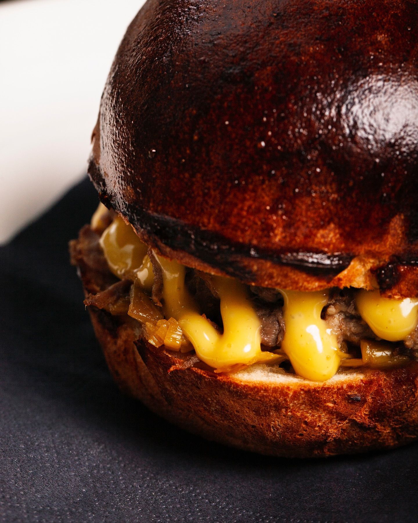 Un primo piano di un hamburger su un piatto nero