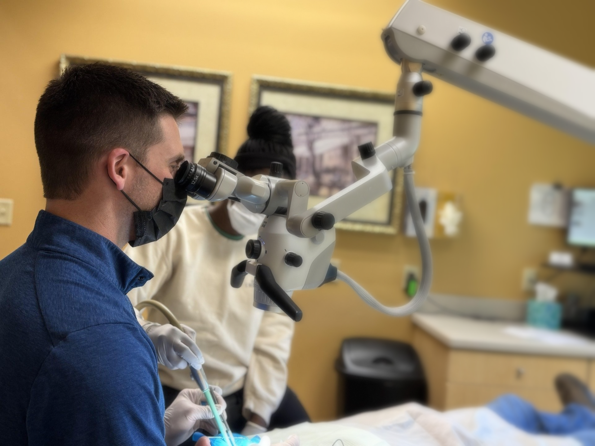 Dentist using microscope on a patient in a dental office.