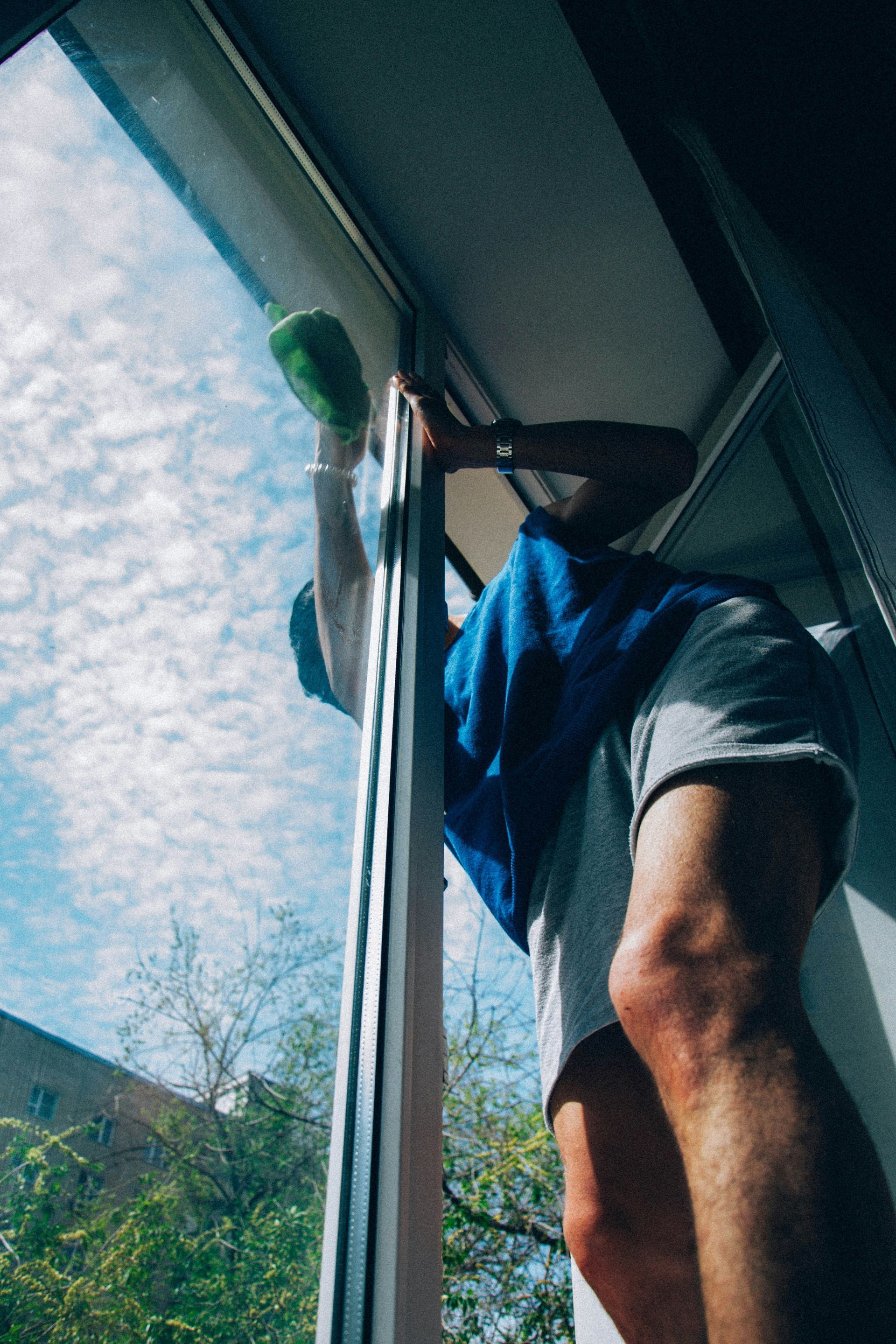 Man wiping the exterior of a full-length window