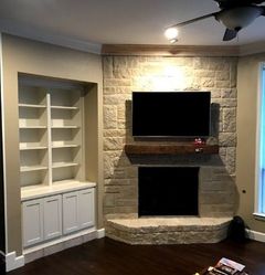 Fireplace with lit flames, surrounded by gray tile and white mantel.