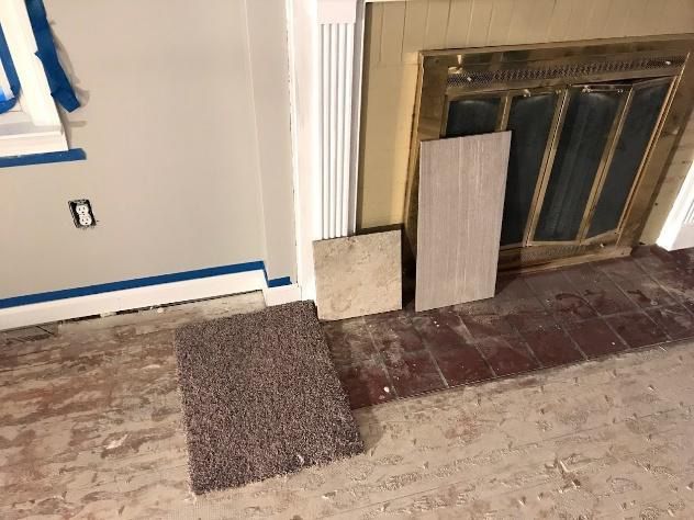 Samples of carpet and tile next to a fireplace and painted wall.