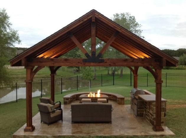 Wooden outdoor gazebo with seating, fire pit, and built-in grill area.