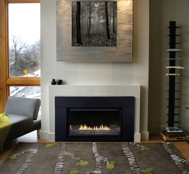 Modern living room with fireplace, artwork, chair, and patterned rug.