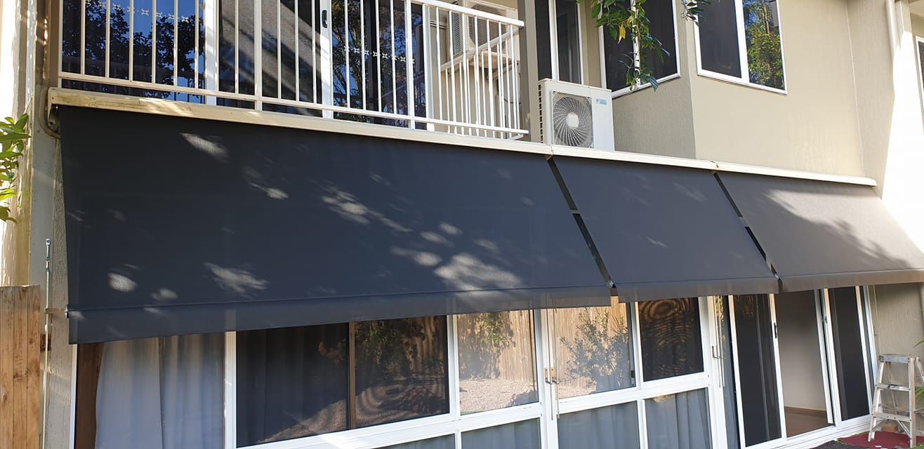Black Awning is on the Side of a Building — Tropical Shade Blinds in Port Douglas, QLD