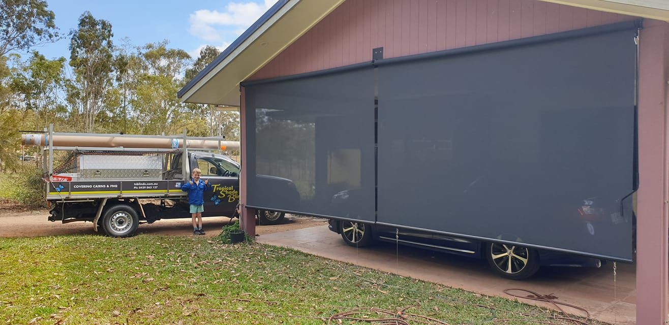 Man is Standing Next to a Truck Parked in Front of a House — Tropical Shade Blinds in Brinsmead, QLD
