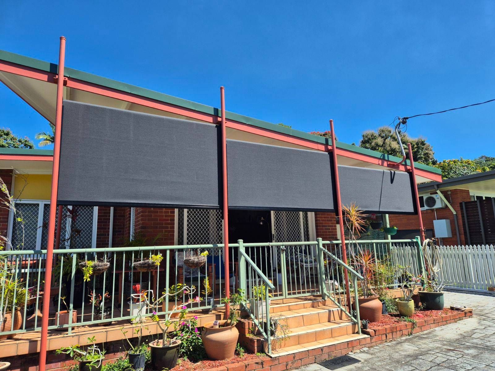 Three Zipscreens At The Front Of A House With Garden Furniture And Brown Steps — Tropical Shade Blinds in Brinsmead, QLD