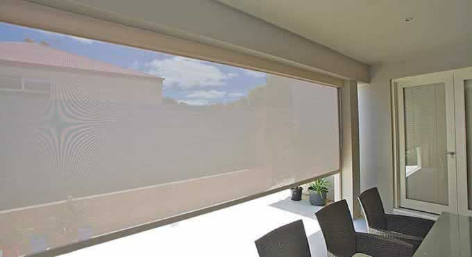 Dining Room With a Table and Chairs and a Large Window With a Blind on It — Tropical Shade Blinds in Brinsmead, QLD