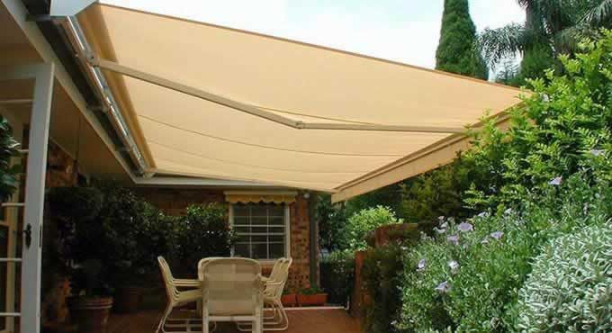 Patio With a Table and Chairs Under an Awning — Tropical Shade Blinds in Brinsmead, QLD