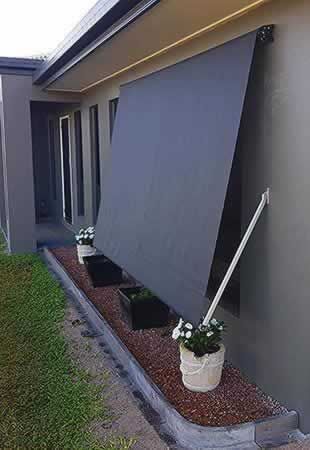 House With a Gray Awning on the Side of It — Tropical Shade Blinds in Brinsmead, QLD