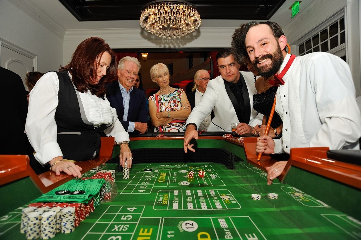 Guests enjoying the craps table with entertaining dealers