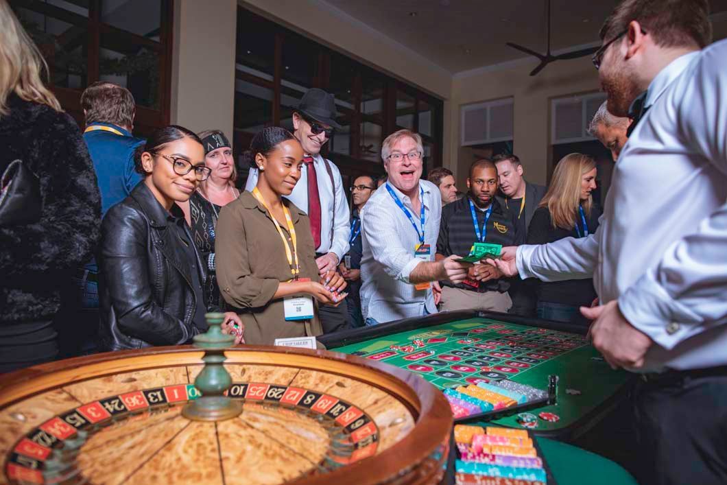 Guests enjoying a roulette table at a fundraising casino party.