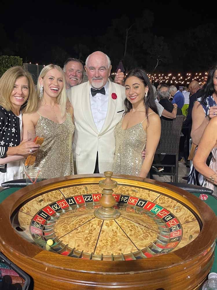 James Bond impersonator with Bond girls enjoying a Roulette game.