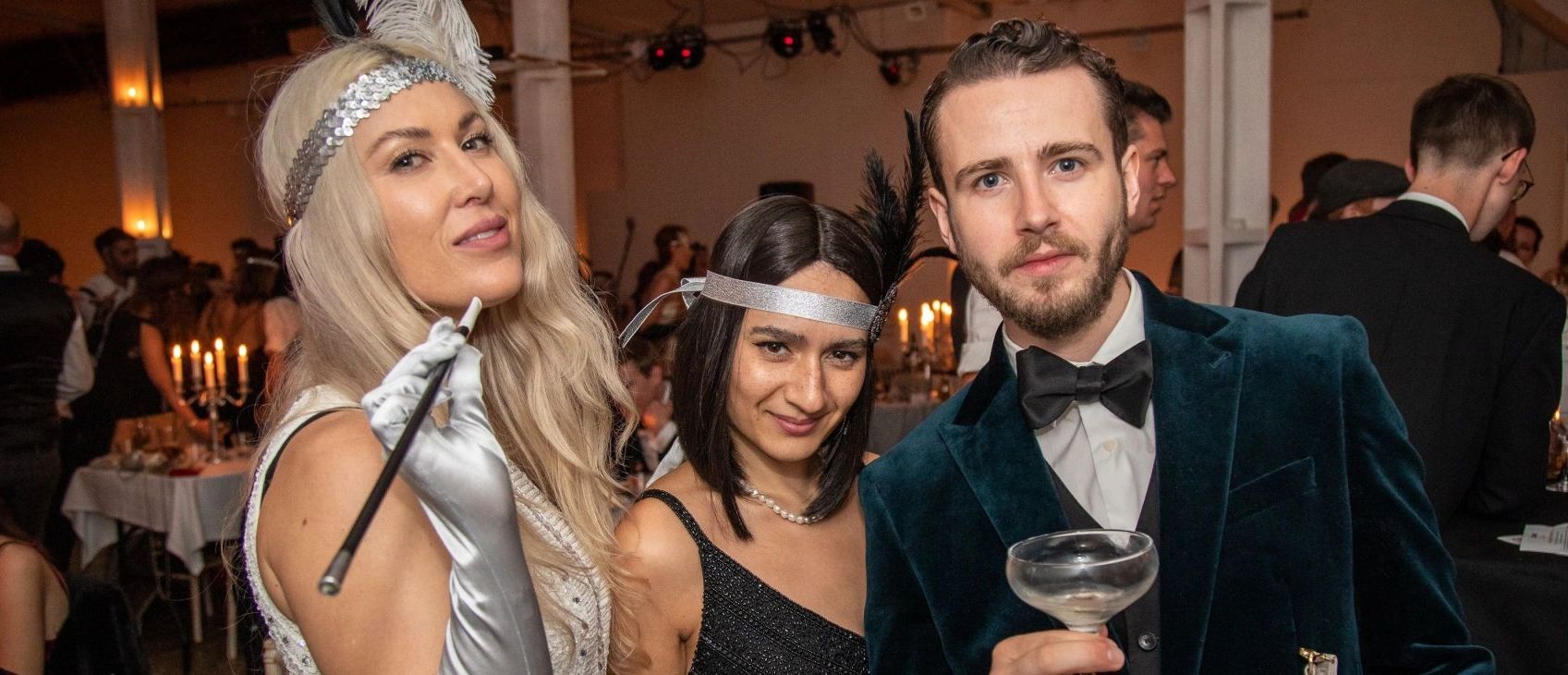 A man and two women are posing for a picture at a party.