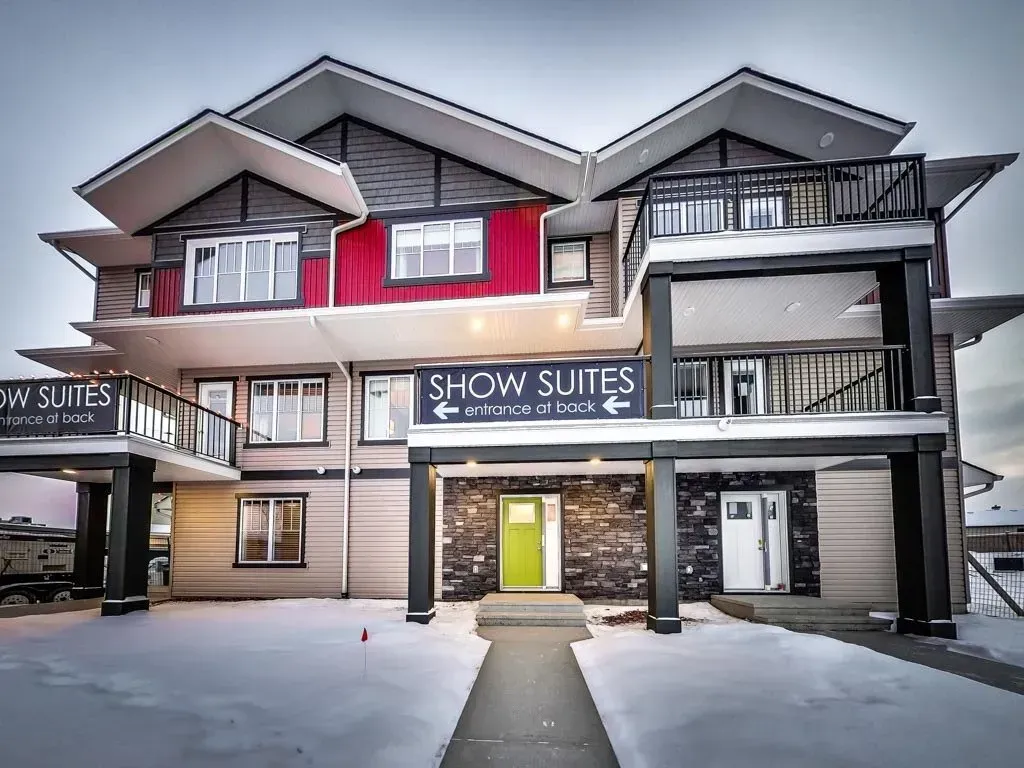 Multi-story building with show suites; red accents, black and grey exterior; snow.