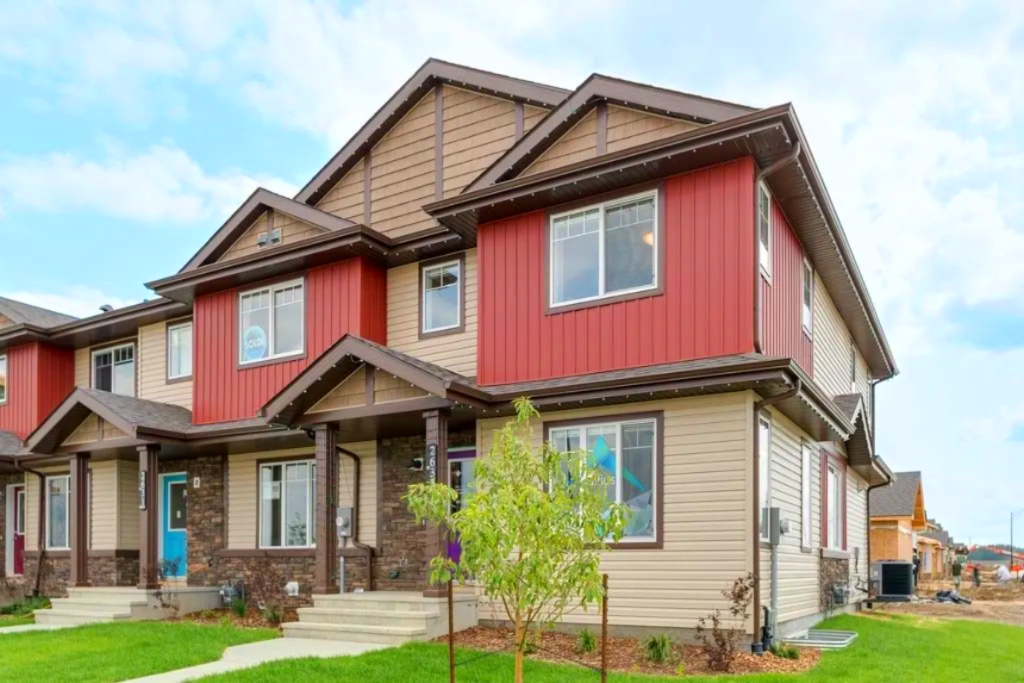 Row of townhouses with red and tan siding and brown trim.