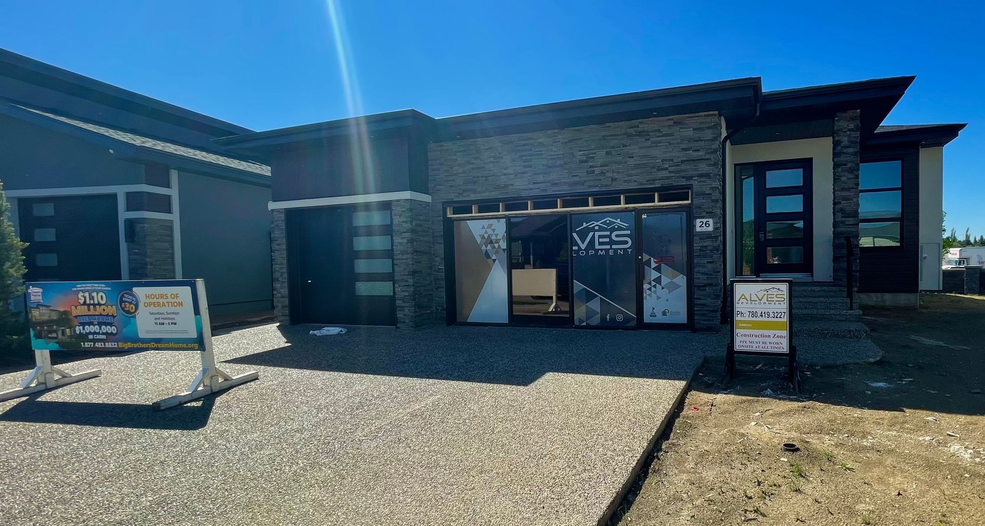 Modern house exterior with stone facade, gravel driveway, and