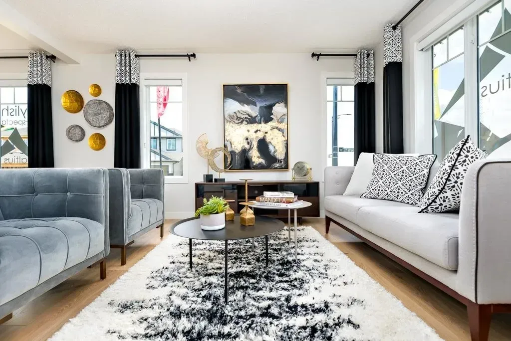 Living room with light gray sofa, black and white rug, and wall art.