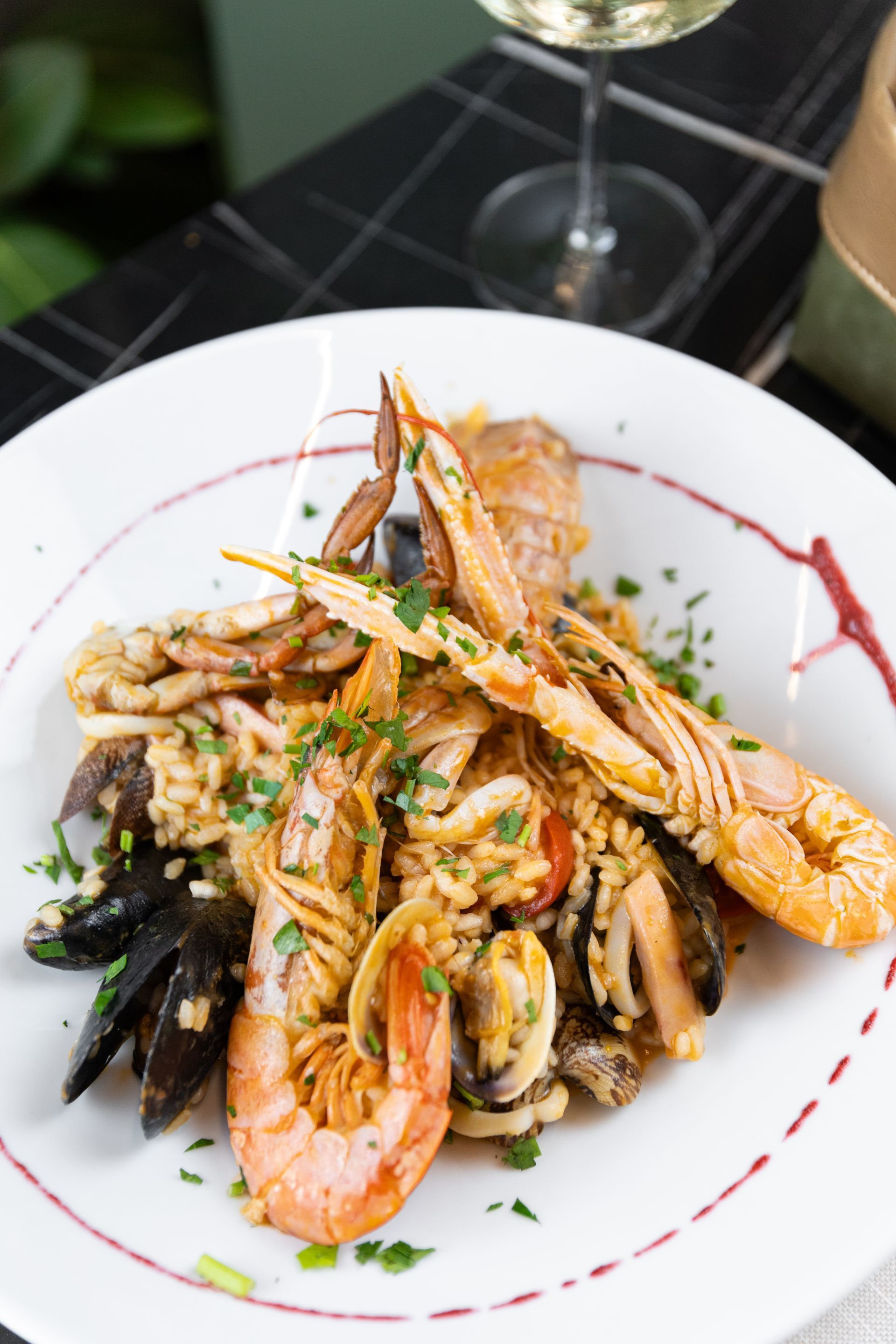 due piatti di paccheri con gamberi, astice e pomodorini