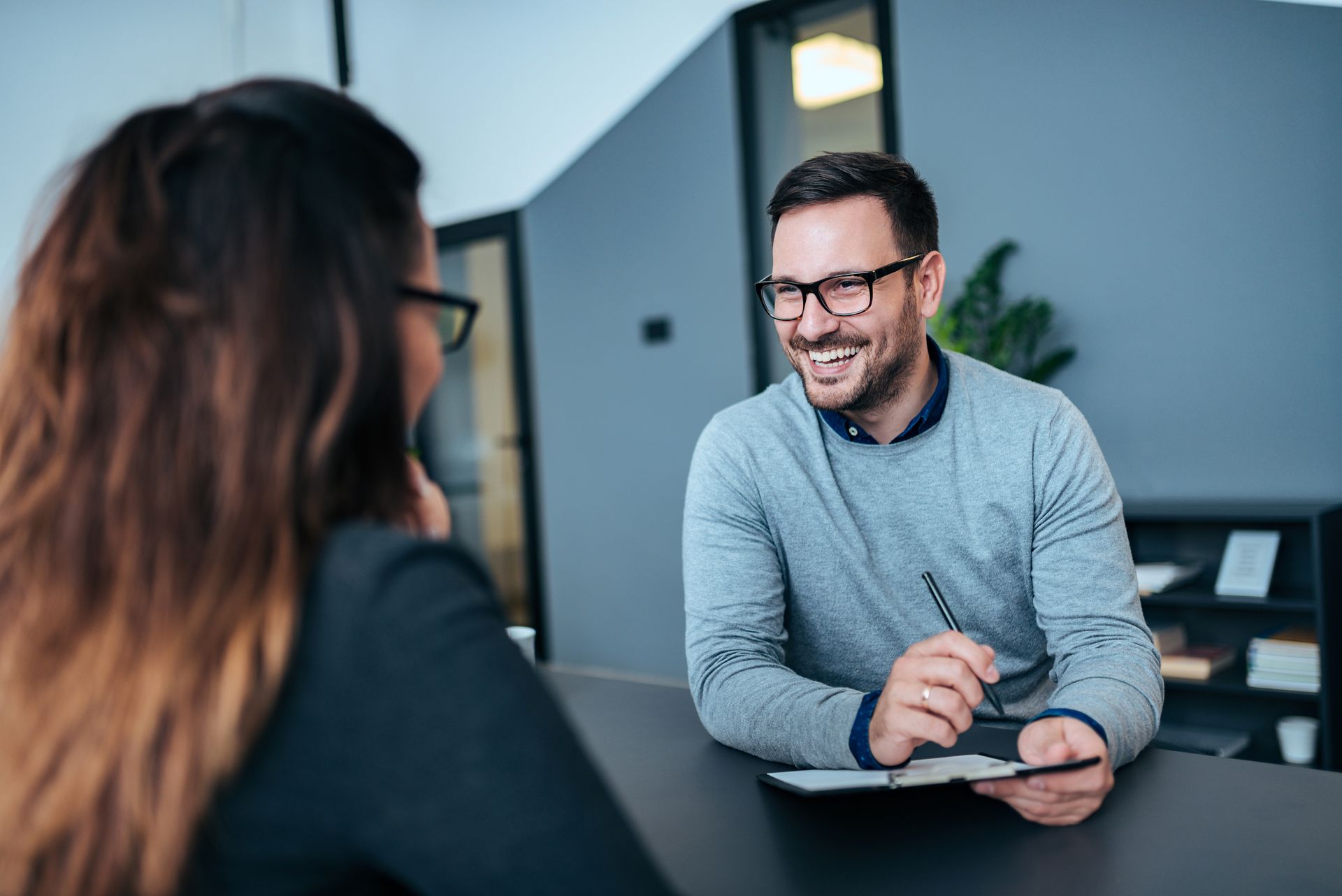 A man and a woman are sitting at a table having a job interview.