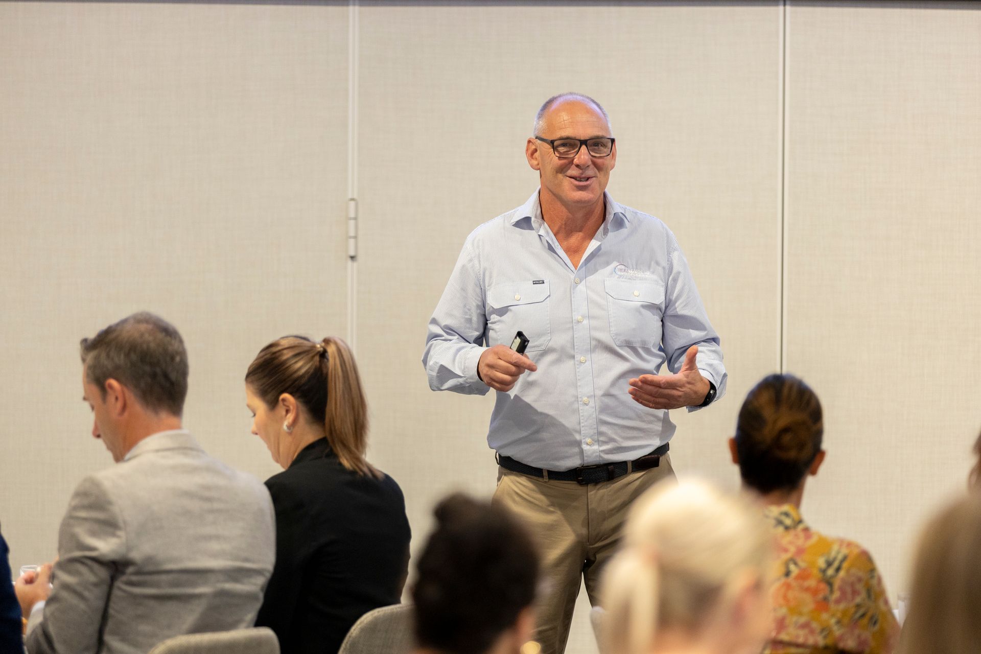 A man is giving a presentation to a group of people sitting in chairs.
