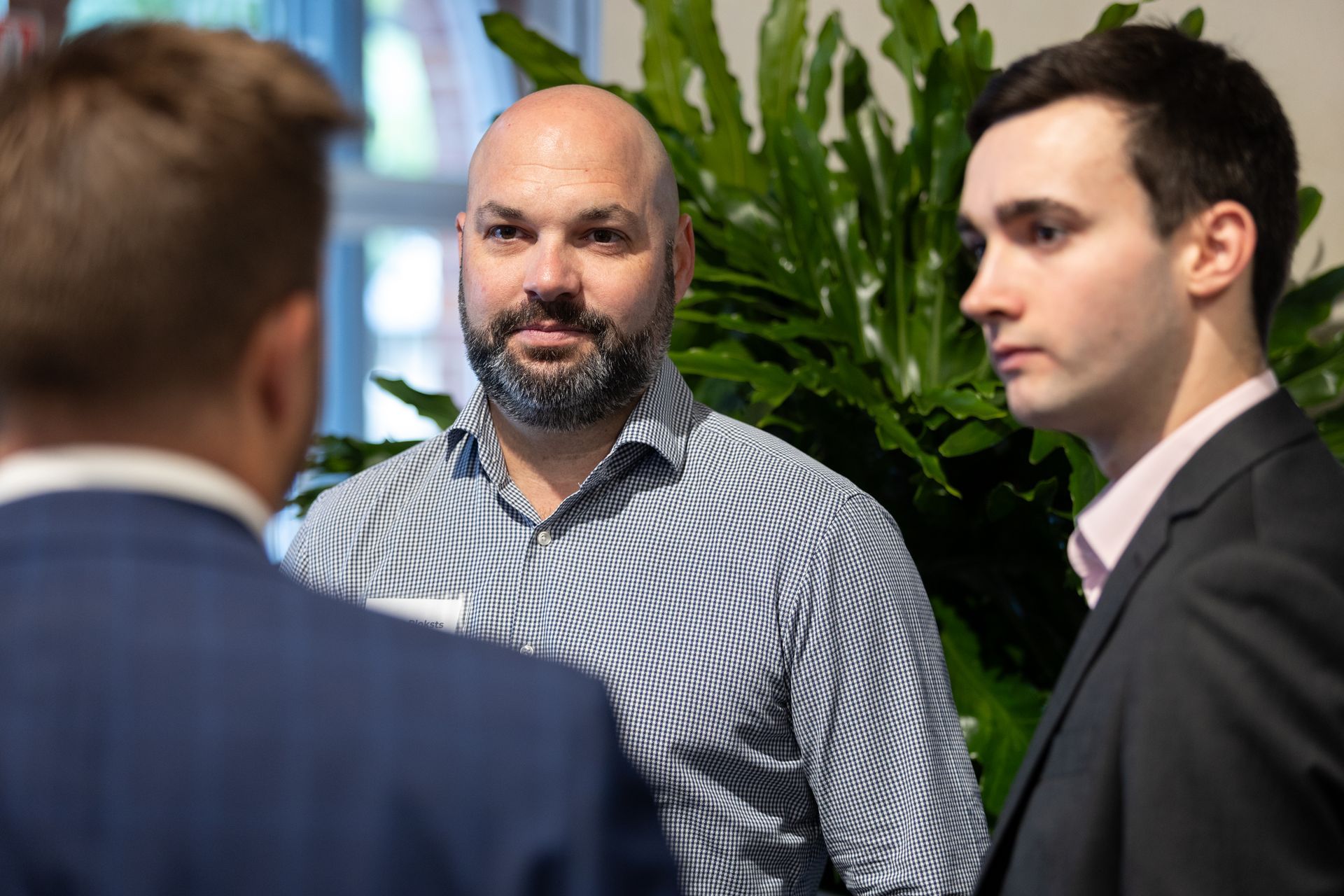 A group of men are standing next to each other and talking in a room.
