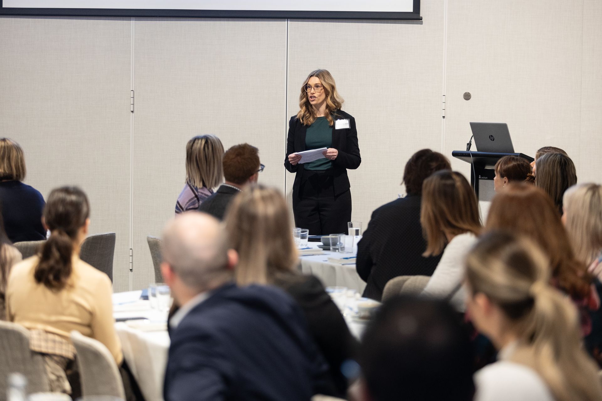 A woman is giving a presentation to a group of people in a conference room.