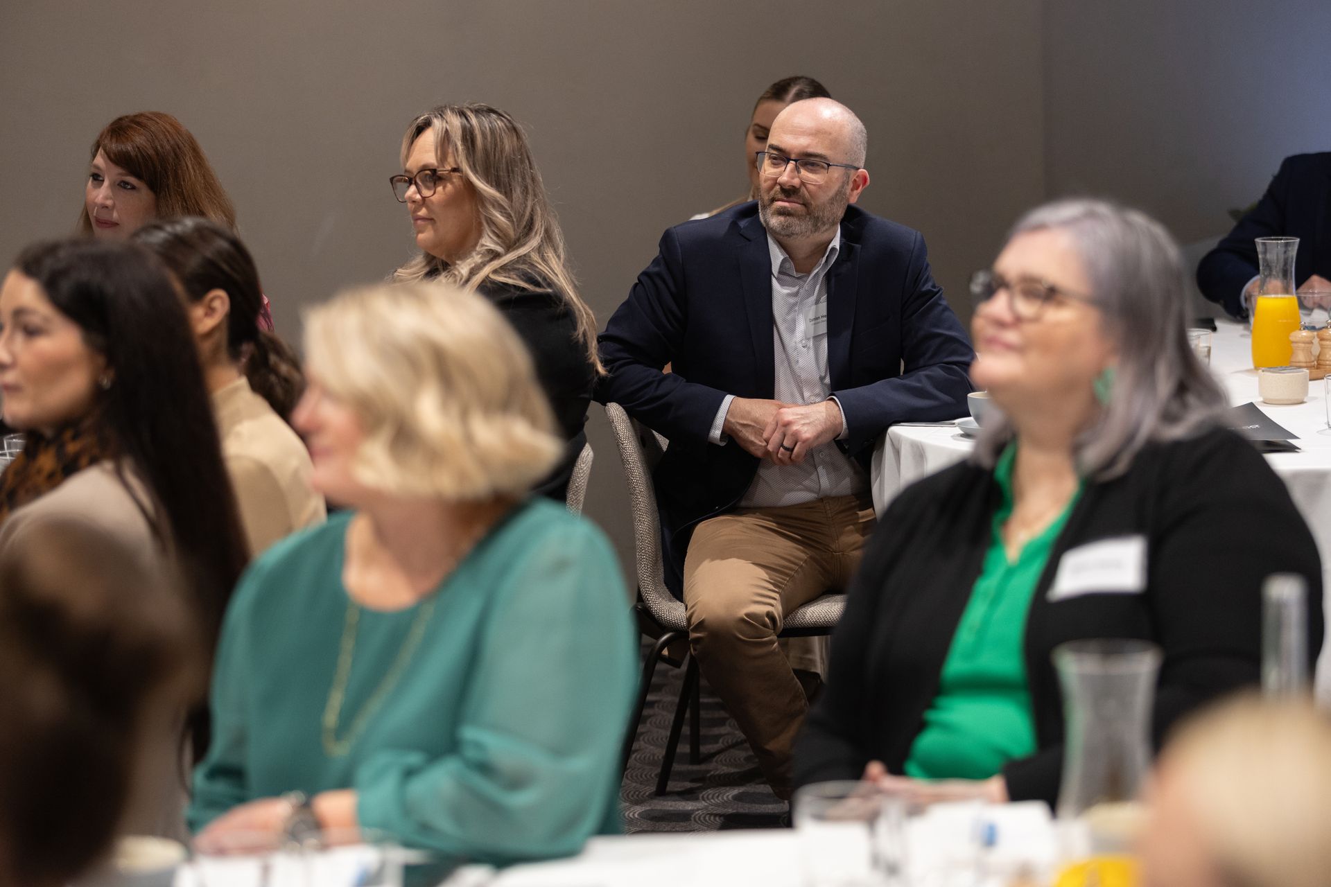 A group of people are sitting at a table at a conference.