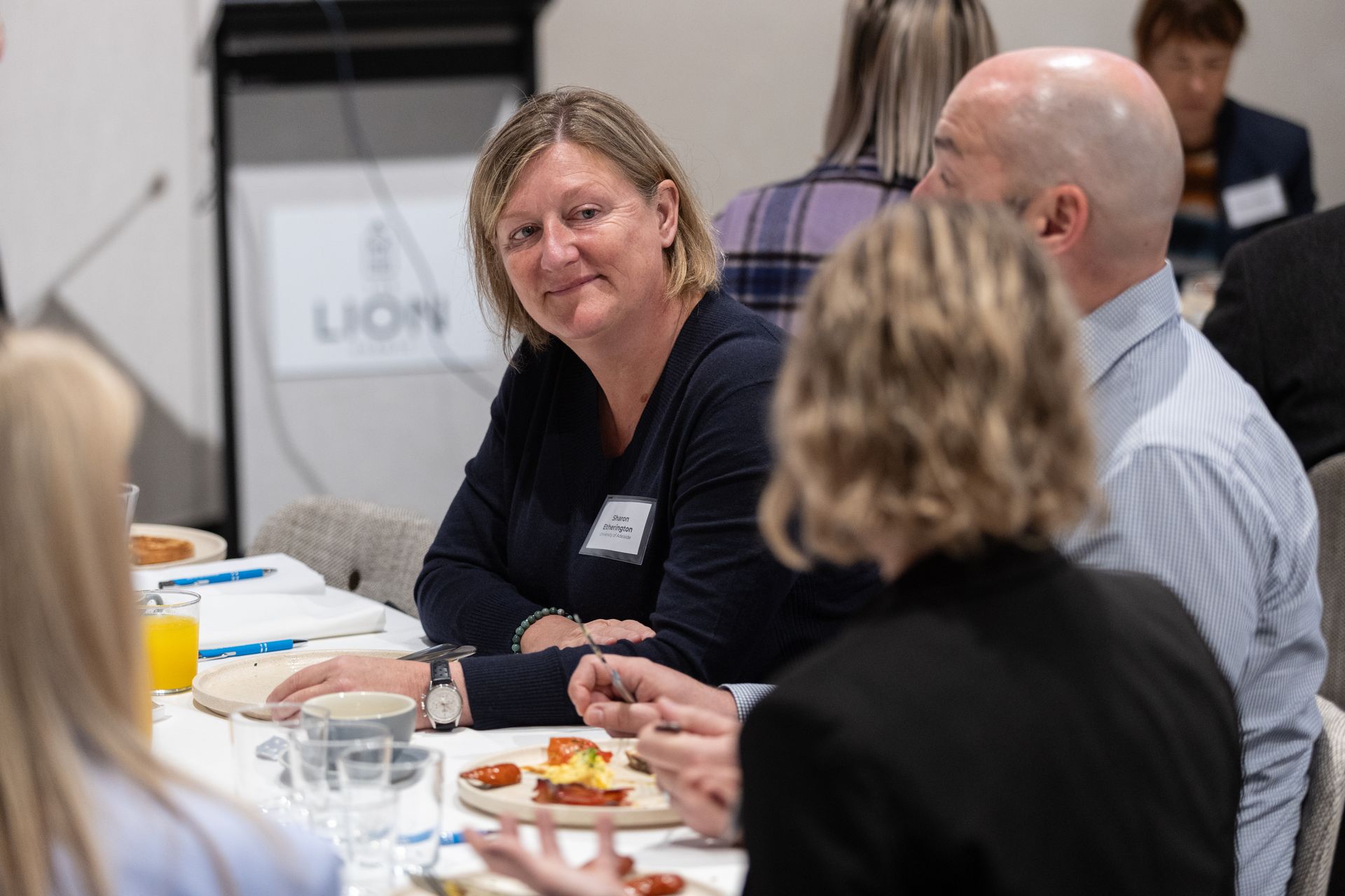 A group of people are sitting at a table eating food.
