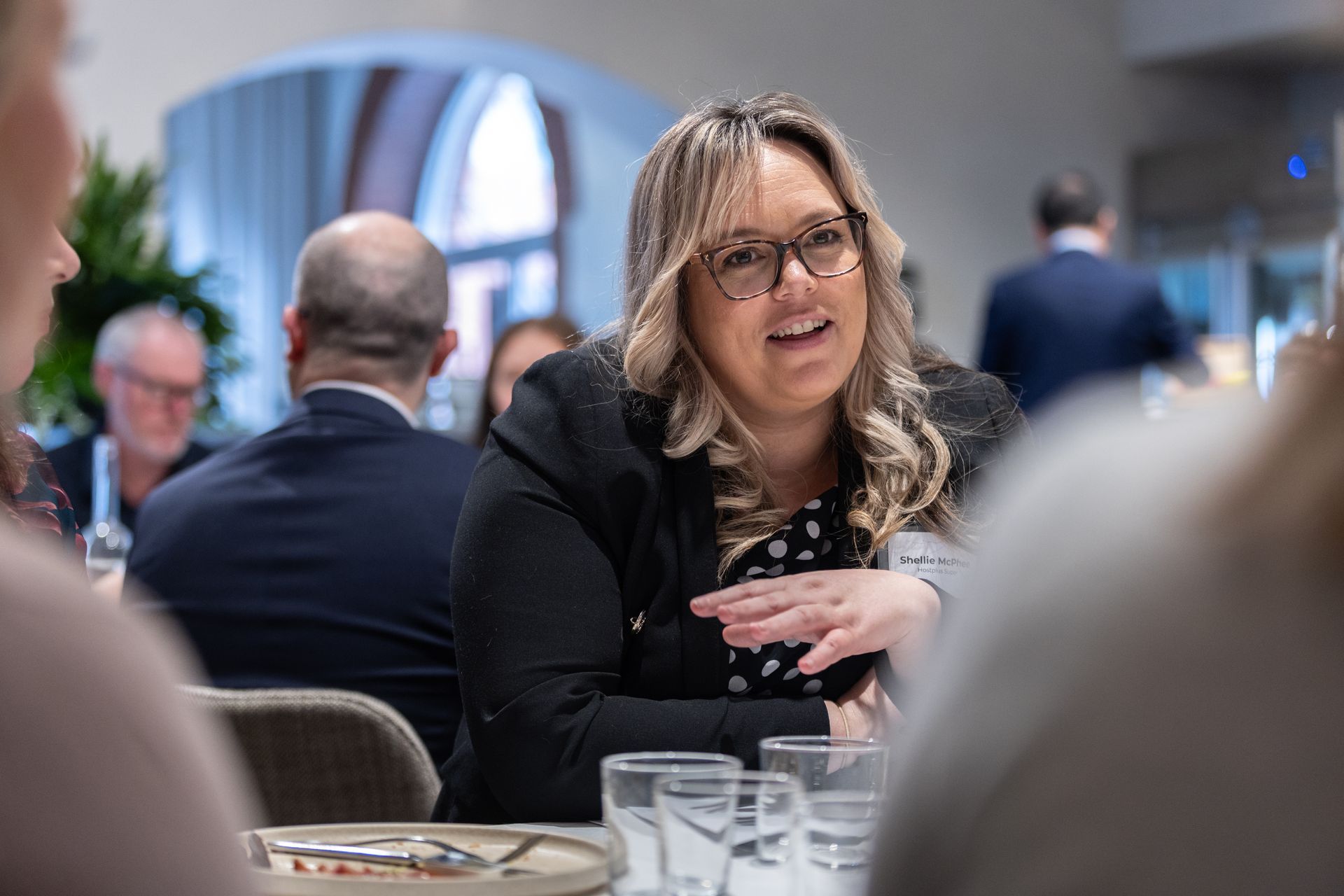 A woman is sitting at a table talking to a group of people.