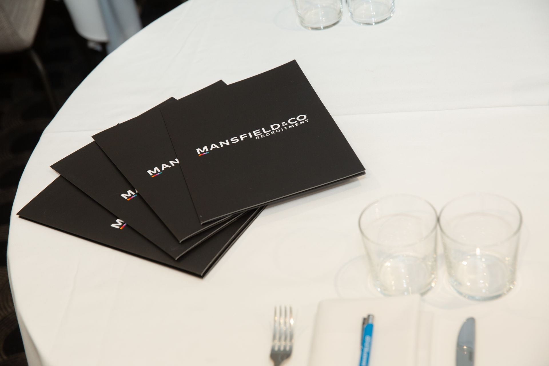 A white table with a stack of menus on it
