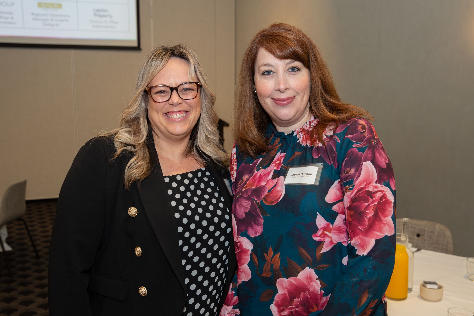 Two women are posing for a picture together in a room.