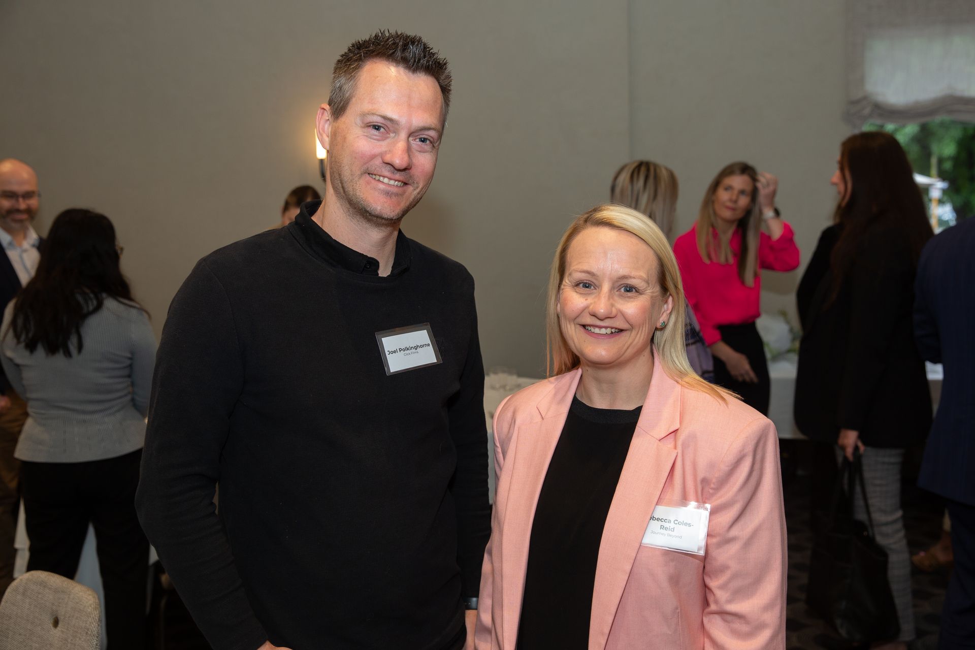 A man and a woman are posing for a picture at a conference.