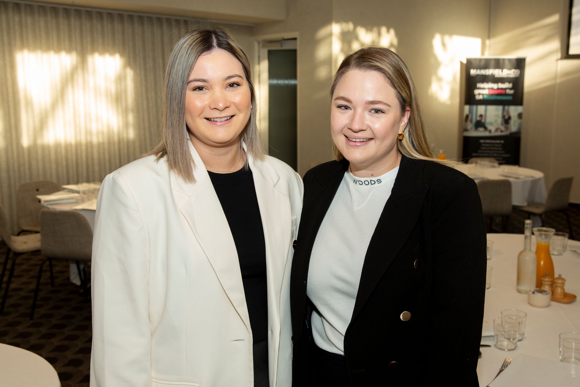 Two women are posing for a picture in a room.
