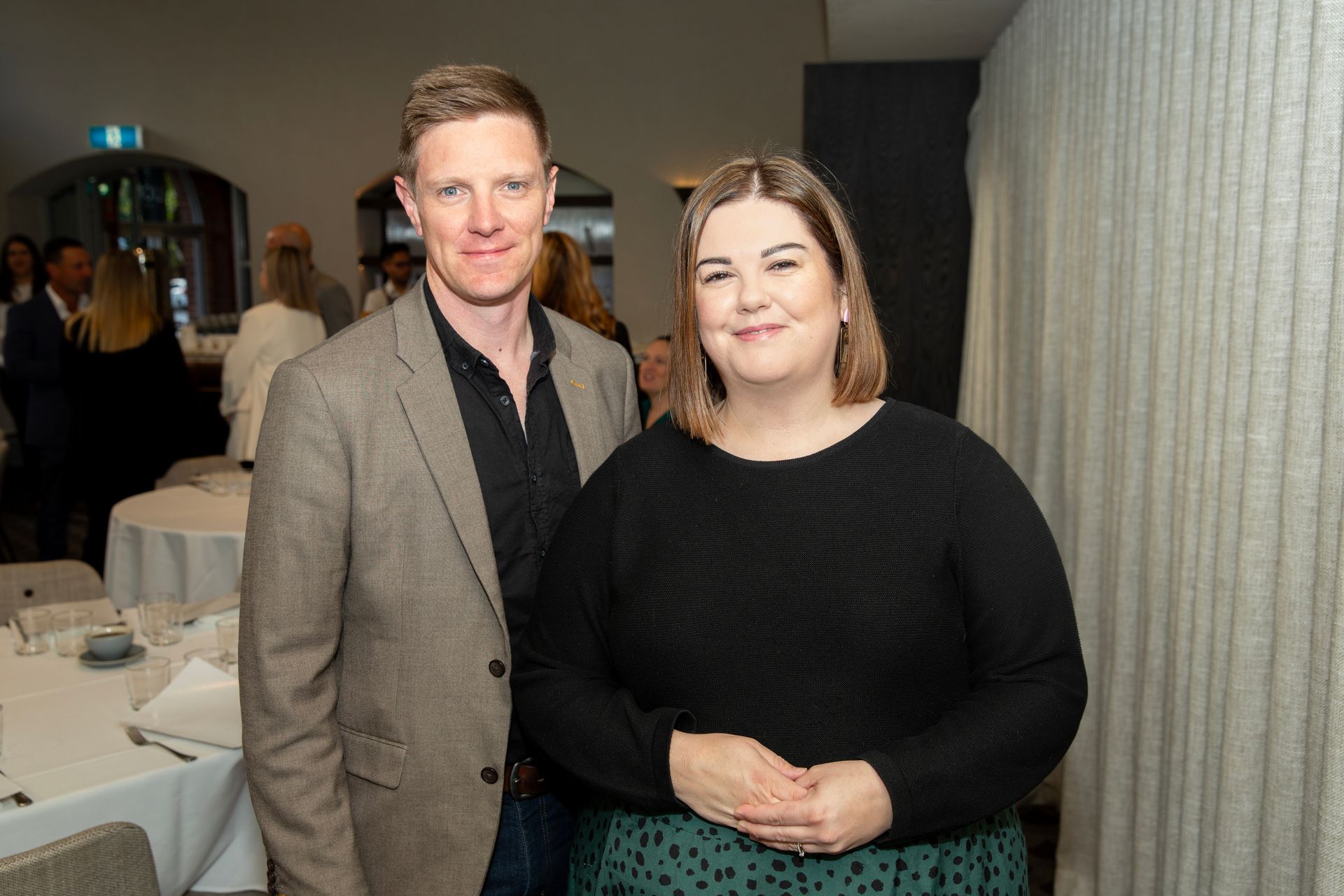 A man and a woman are standing next to each other in a room.