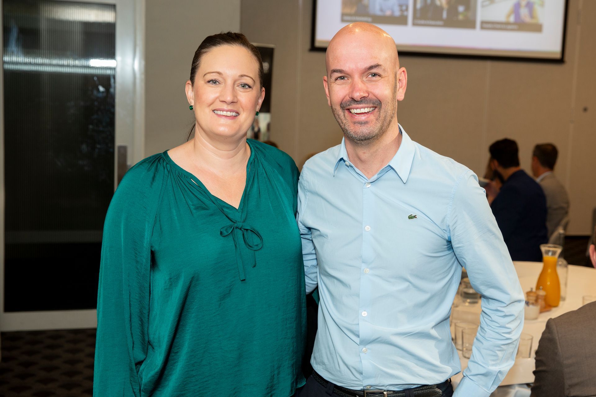 A man and a woman are posing for a picture in a room.