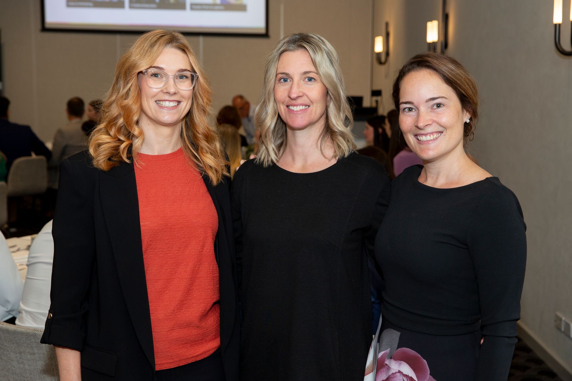 Three women are posing for a picture together in a room.