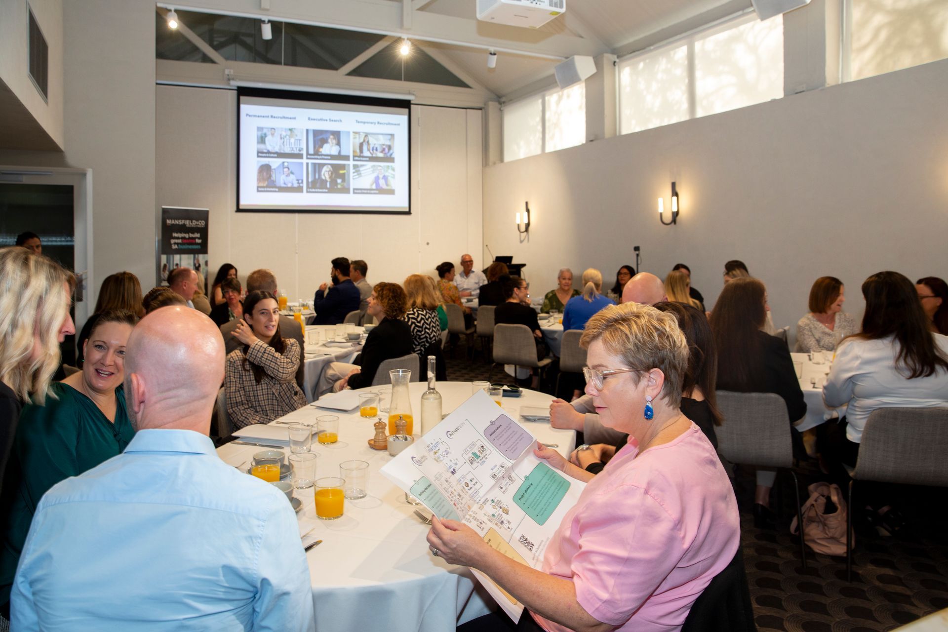 A group of people are sitting at tables in a room.