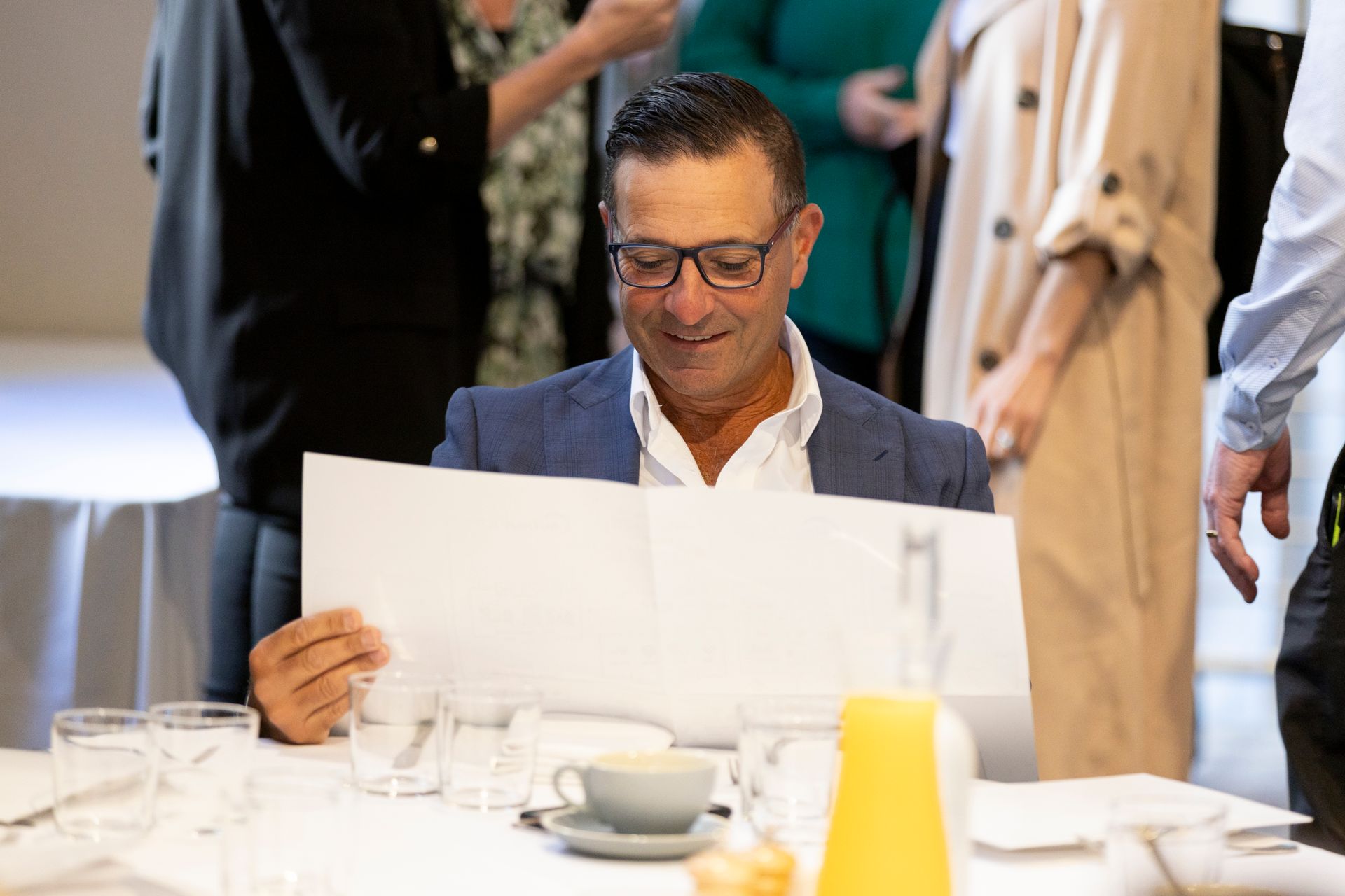 A man is sitting at a table reading a book.