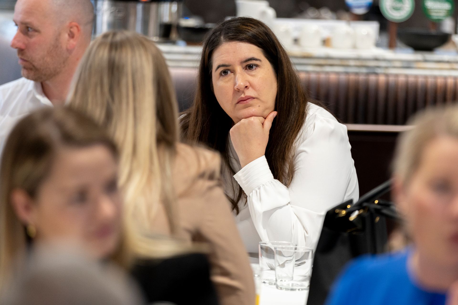 A group of people are sitting at a table in a restaurant.