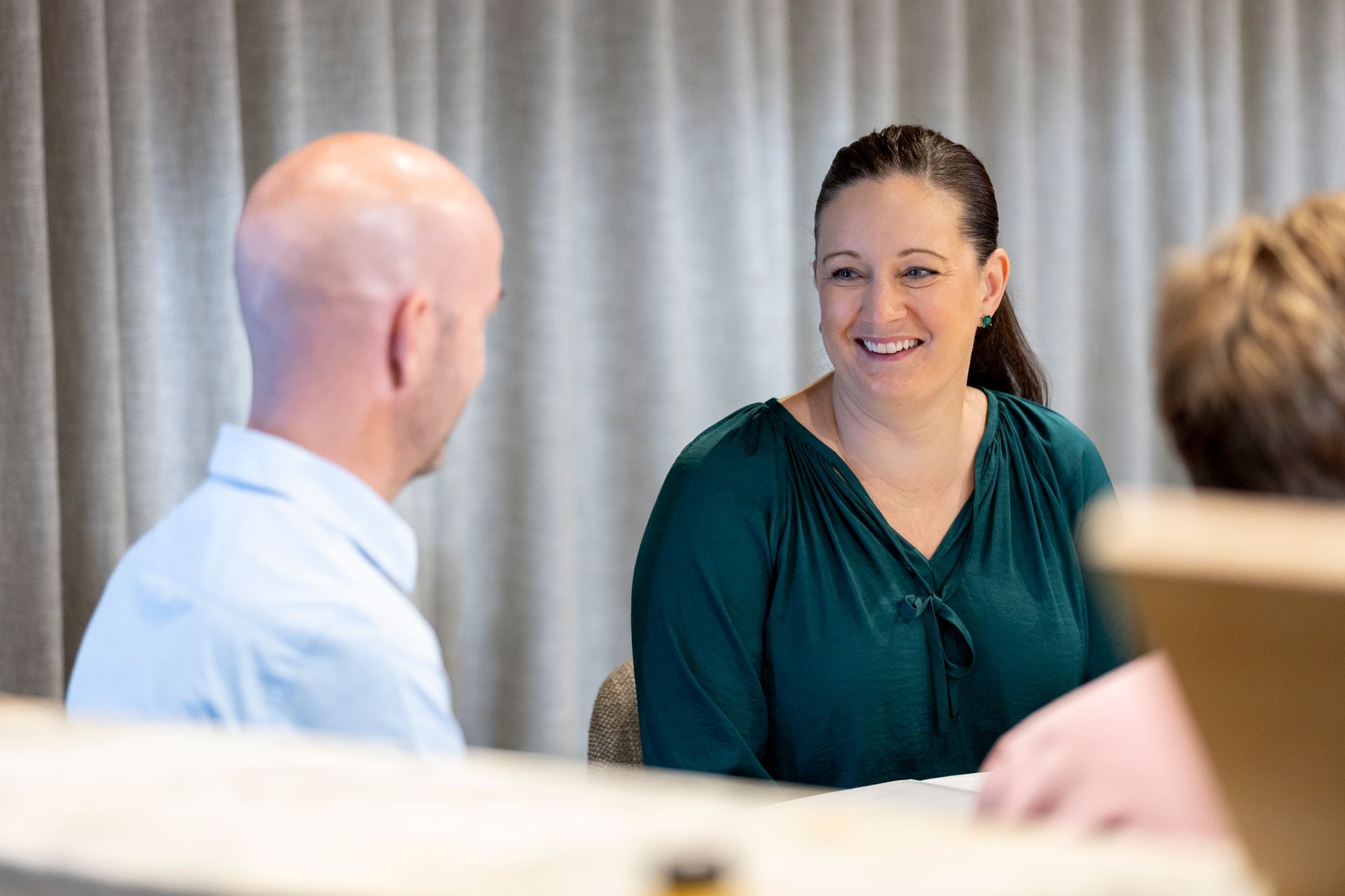 A man and a woman are sitting at a table having a conversation.