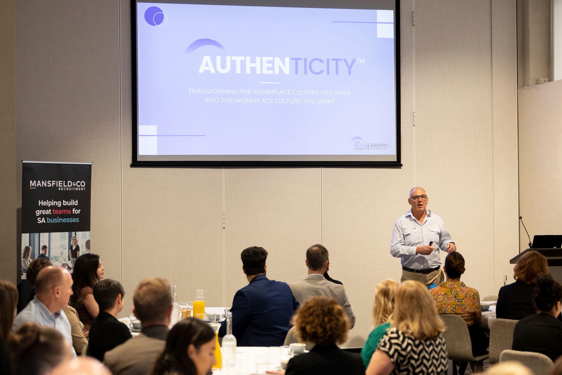 A man is giving a presentation to a group of people at a conference.