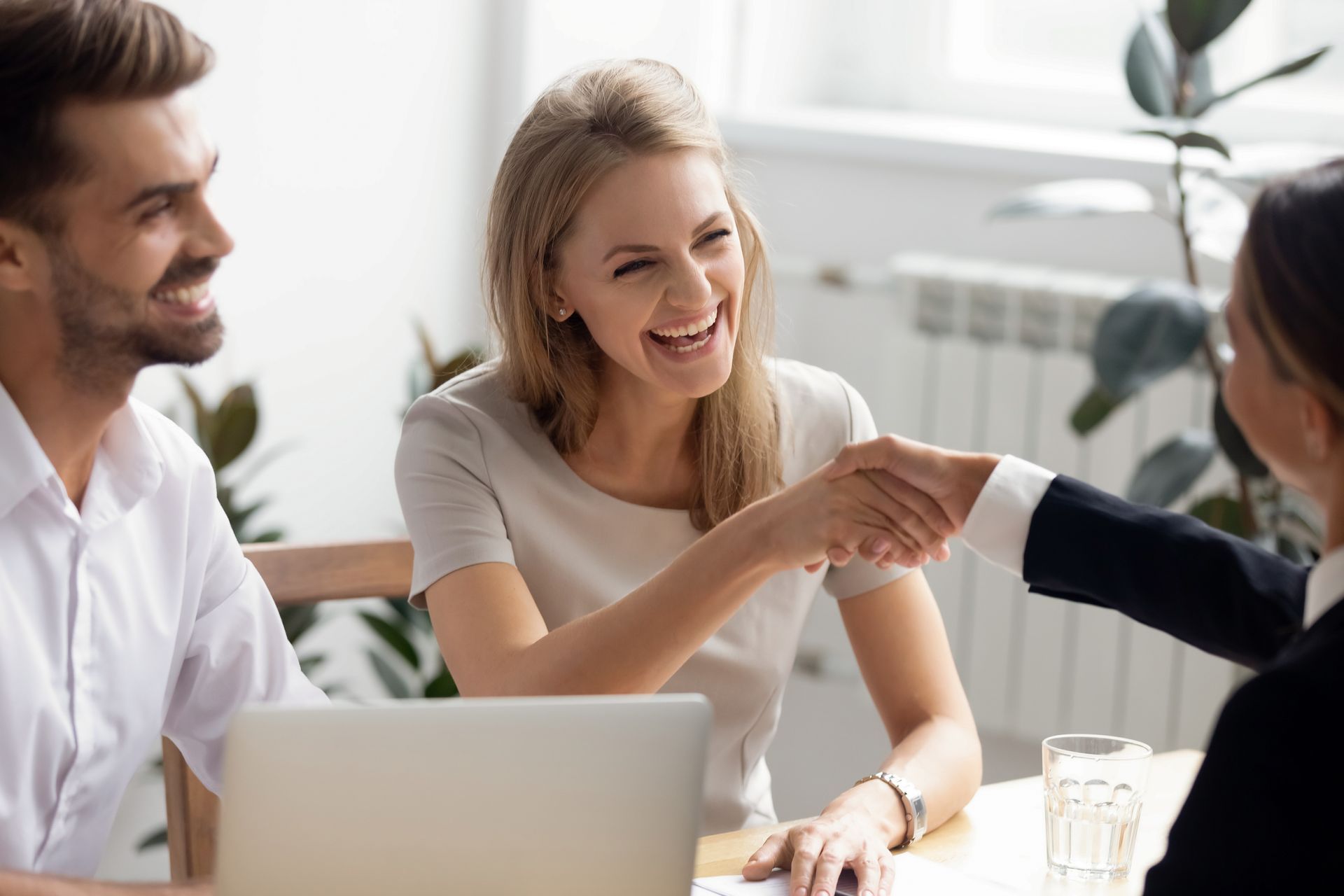 Excited laughing businesswoman shaking hand of business partner at successful meeting, happy hr mana