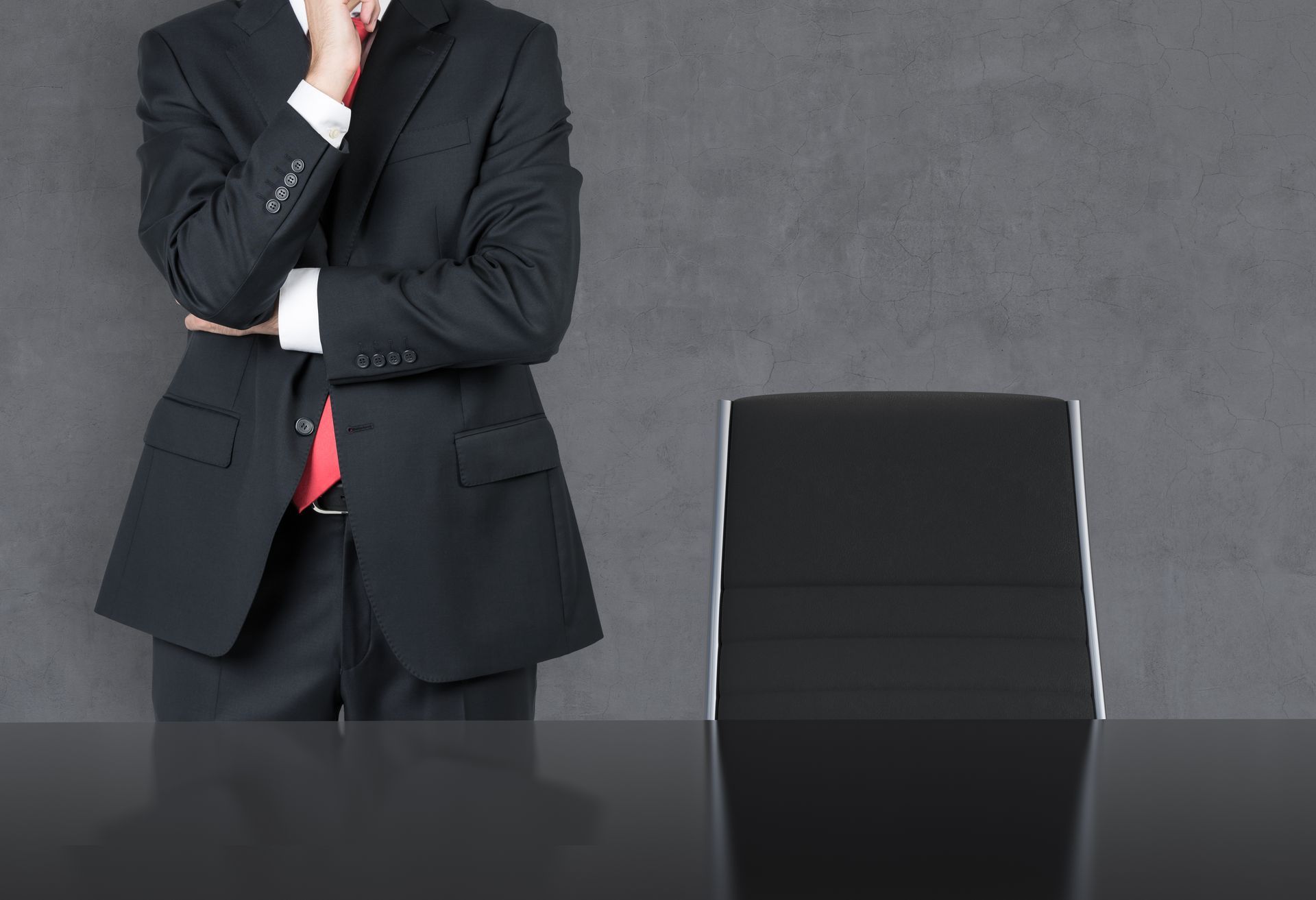 Thinking businessman in a suit in a dark Room with Chair and Table