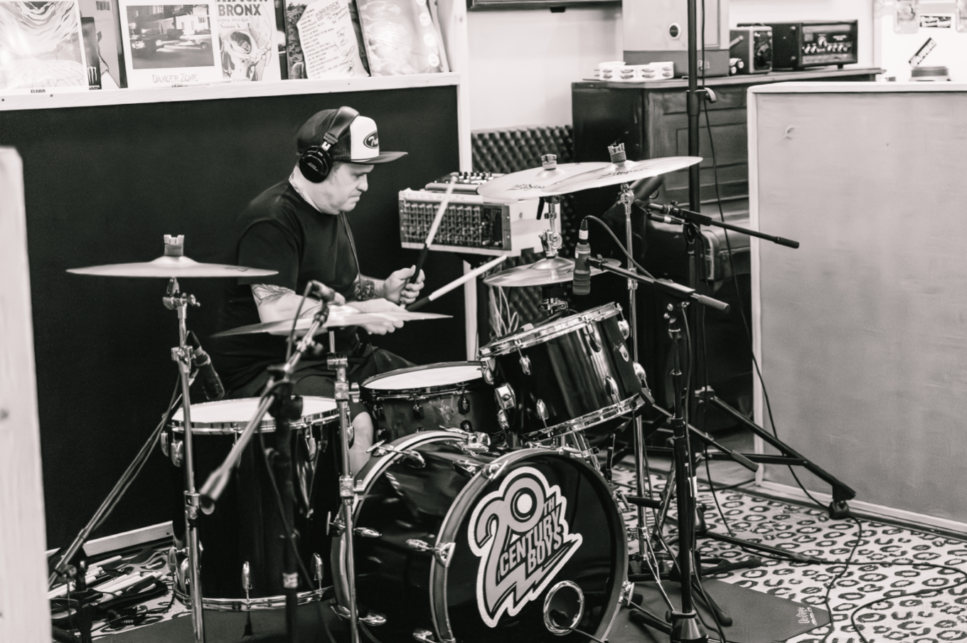 A man is playing drums in a black and white photo.