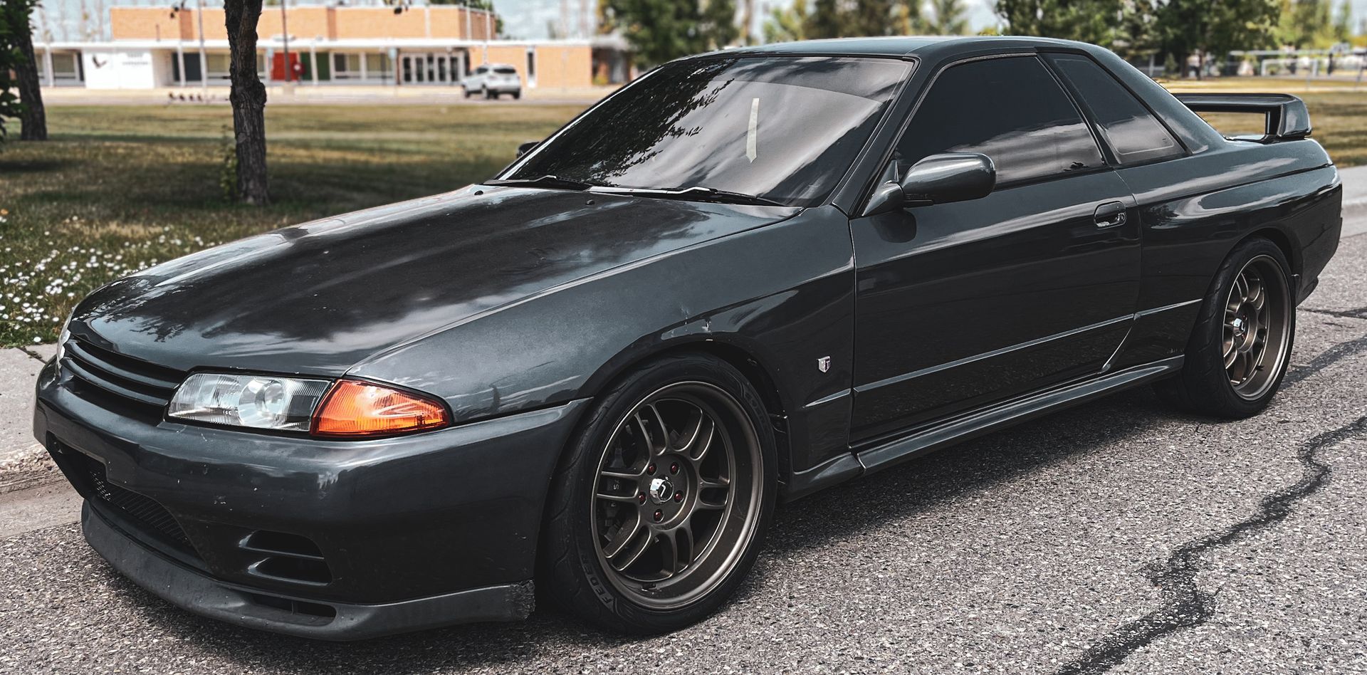 A black car is parked on the side of the road