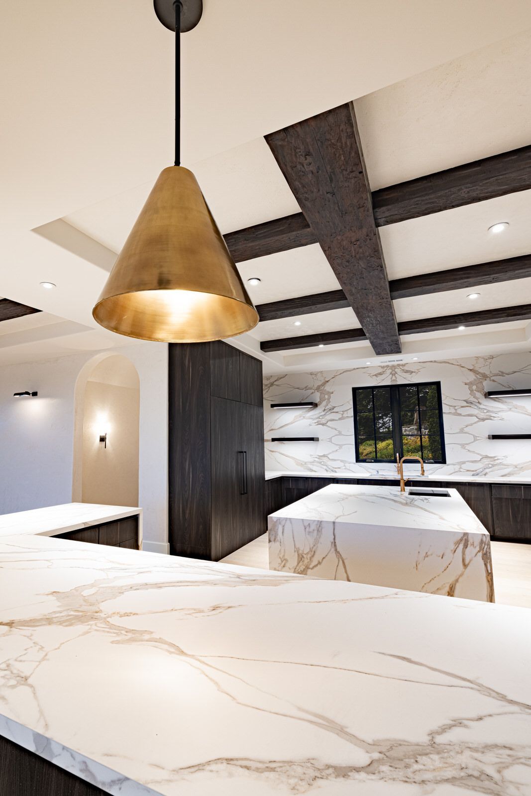 A kitchen with a large island and a pendant light hanging from the ceiling.