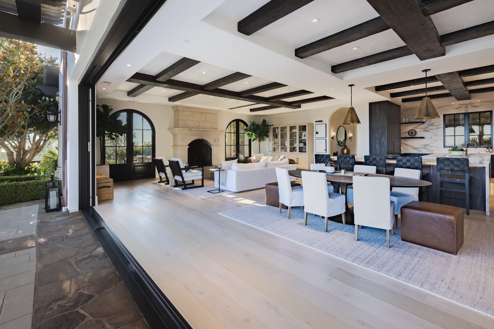 A large living room with a dining table and chairs and a sliding glass door.