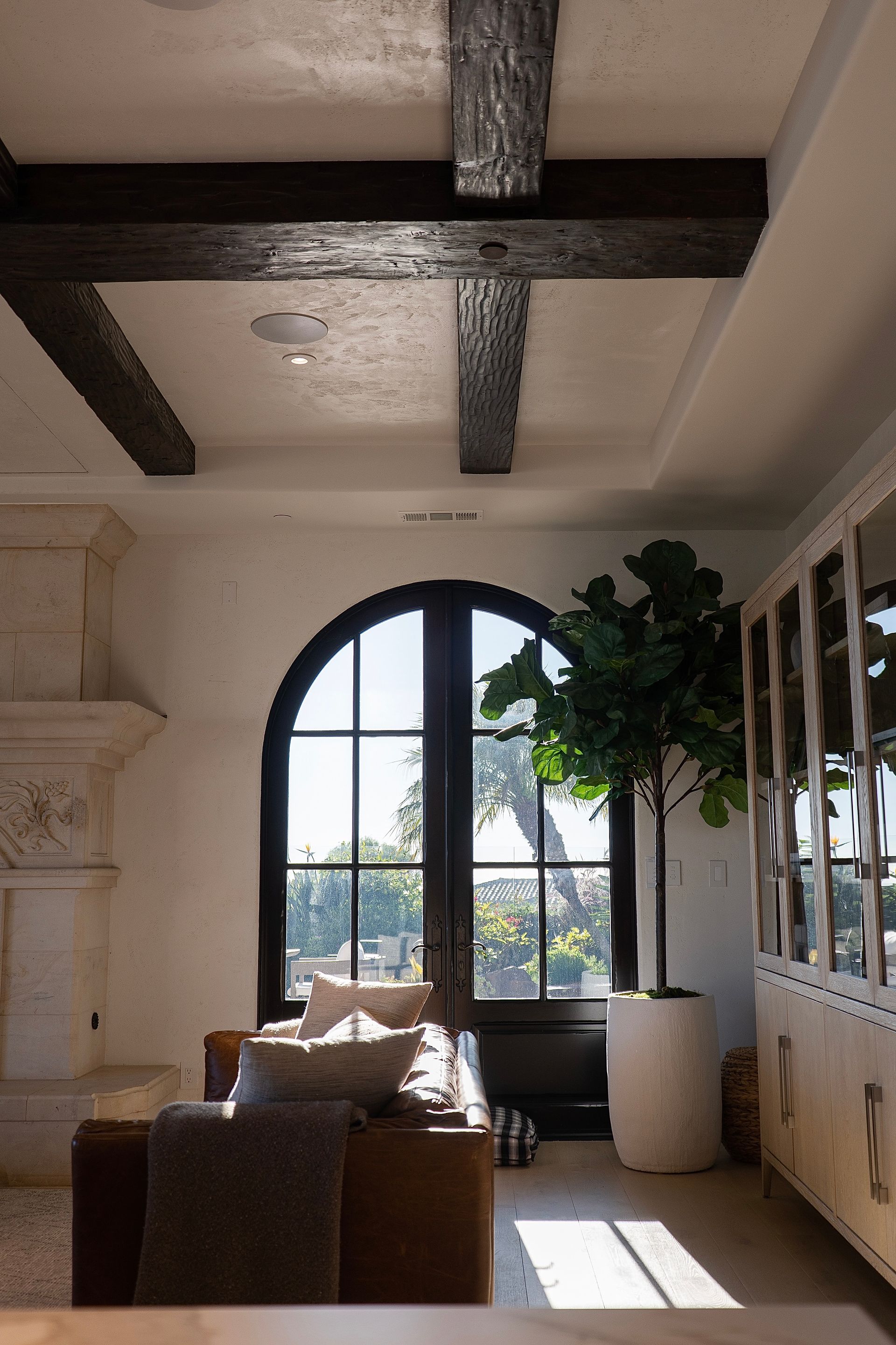 A living room with a couch , fireplace , and a large window.
