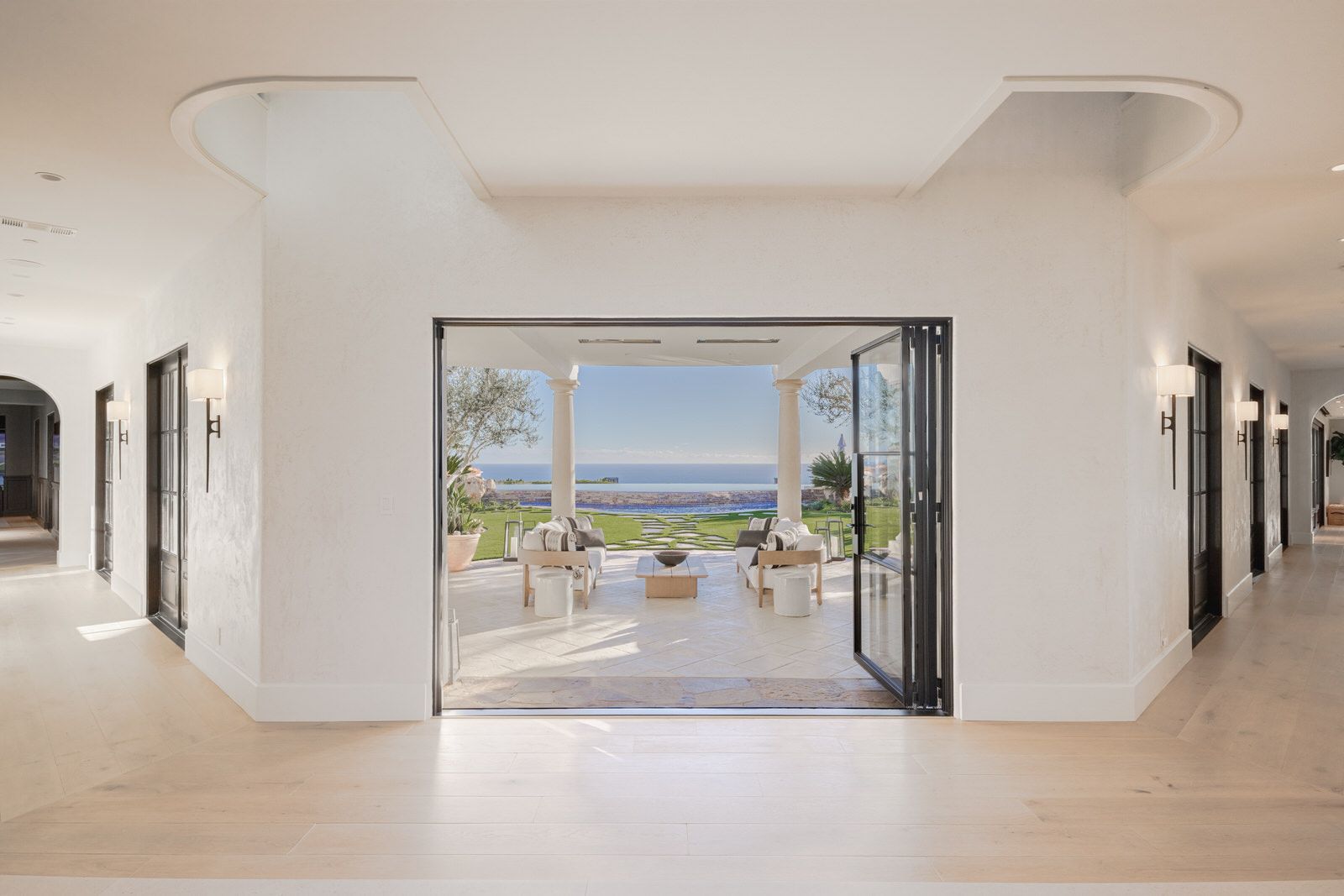 A hallway in a house with a view of the ocean.